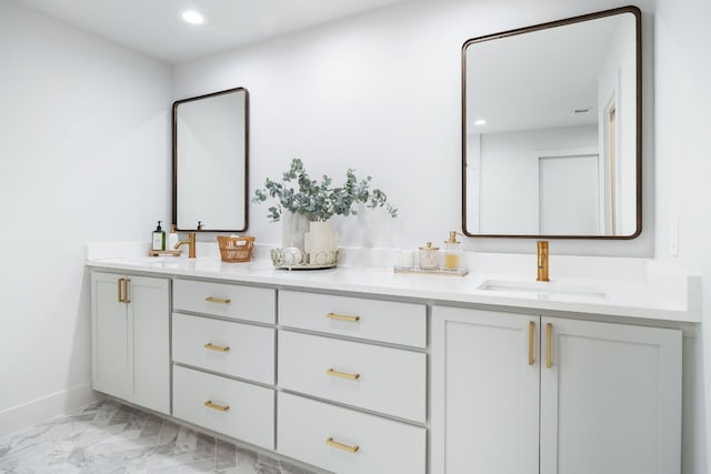 full bath with double vanity, recessed lighting, marble finish floor, and a sink