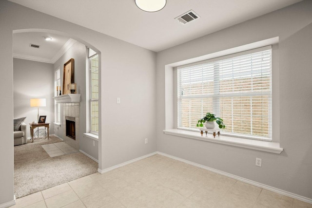 interior space featuring visible vents, arched walkways, baseboards, and a tile fireplace