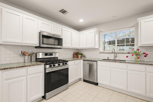 kitchen with visible vents, a sink, tasteful backsplash, stainless steel appliances, and white cabinets