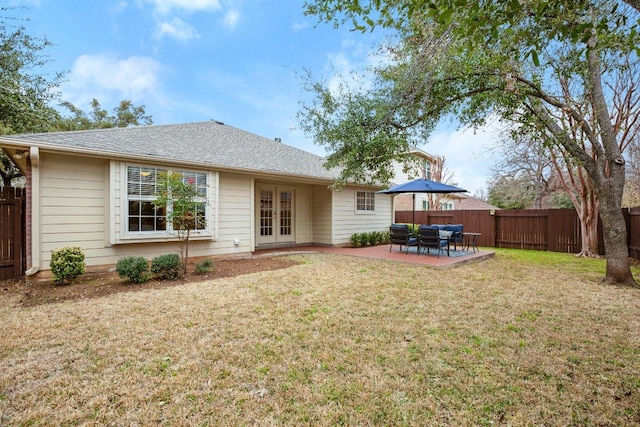 back of property featuring french doors, a patio, a yard, and a fenced backyard