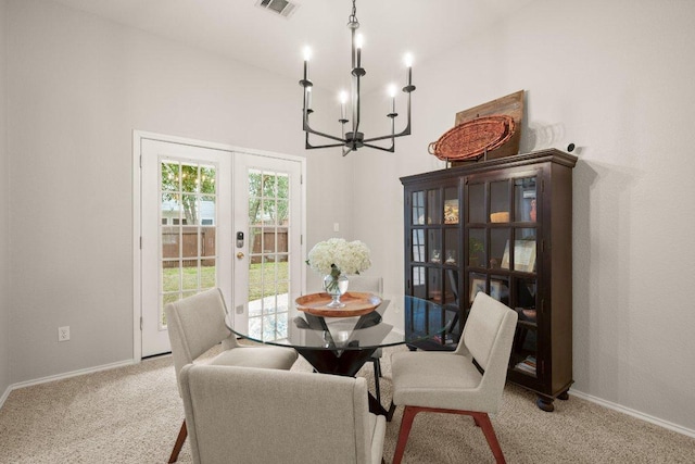 carpeted dining space featuring french doors, baseboards, an inviting chandelier, and visible vents