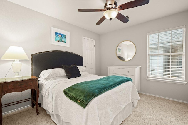 bedroom featuring multiple windows, light carpet, and baseboards