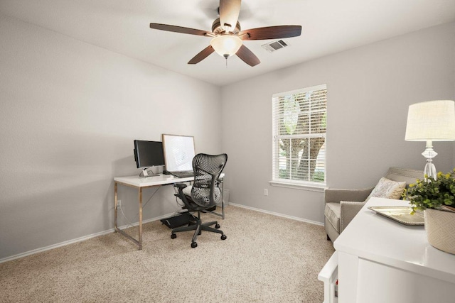 home office with visible vents, baseboards, light colored carpet, and a ceiling fan