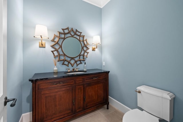 bathroom featuring baseboards, toilet, vanity, and tile patterned flooring