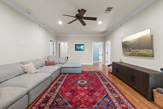 living area with recessed lighting, visible vents, light wood-style flooring, and crown molding