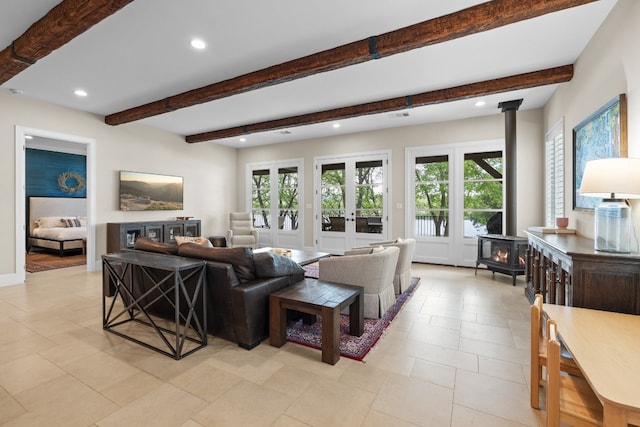 living area with recessed lighting, beamed ceiling, a wood stove, and french doors