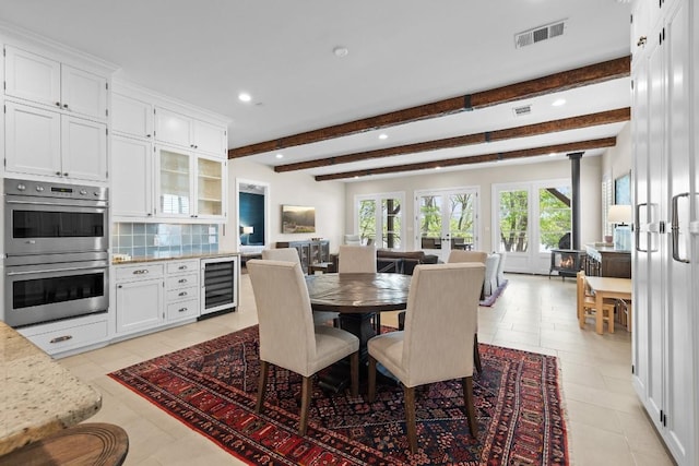 dining area with visible vents, a wood stove, recessed lighting, wine cooler, and beamed ceiling