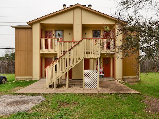 rear view of house with a patio, stairway, a yard, and covered porch