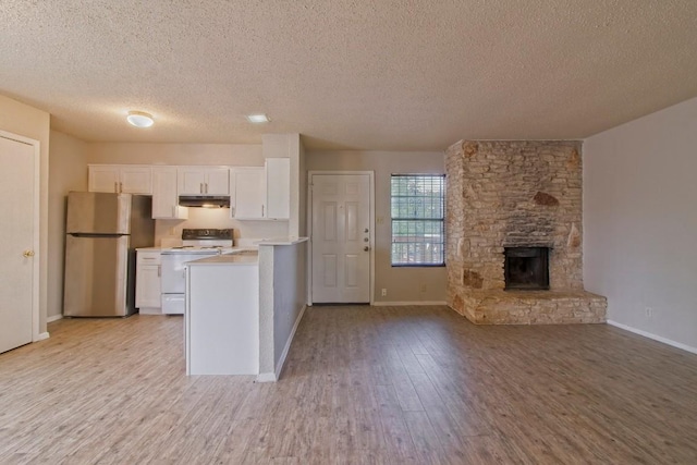 kitchen featuring white electric range, under cabinet range hood, open floor plan, white cabinetry, and freestanding refrigerator