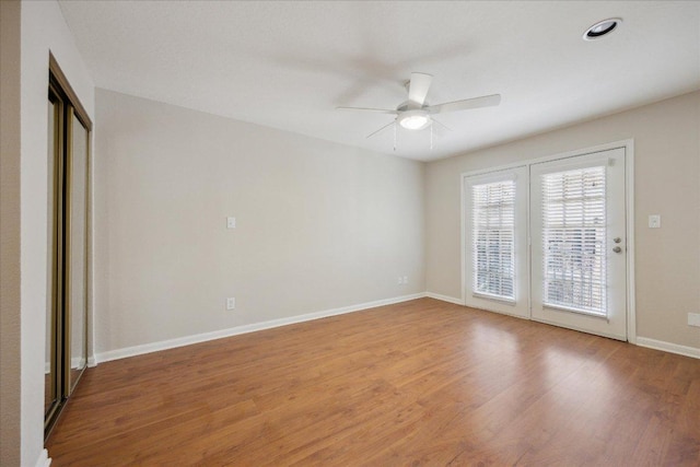 spare room with baseboards, a ceiling fan, and light wood finished floors