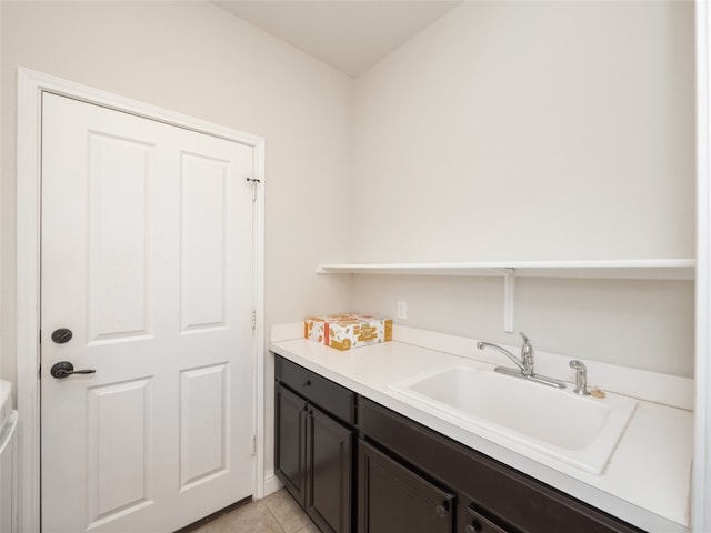 laundry area featuring light tile patterned flooring and a sink