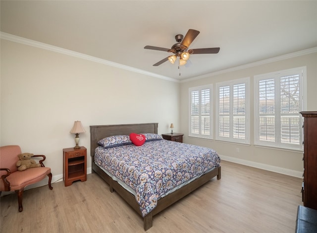 bedroom with light wood-style flooring, crown molding, and baseboards