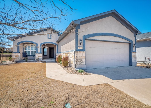 view of front facade featuring a front lawn, stucco siding, a garage, stone siding, and driveway