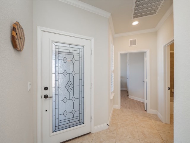 entryway with crown molding, light tile patterned floors, baseboards, and visible vents