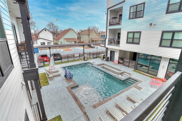 view of swimming pool featuring a patio, a fenced in pool, fence, and a residential view