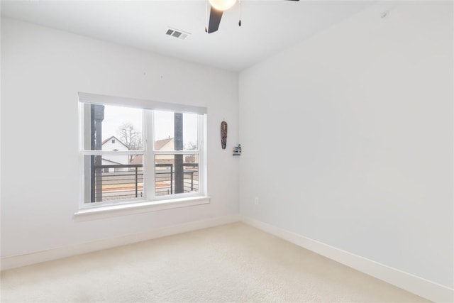 empty room featuring visible vents, carpet floors, baseboards, and ceiling fan