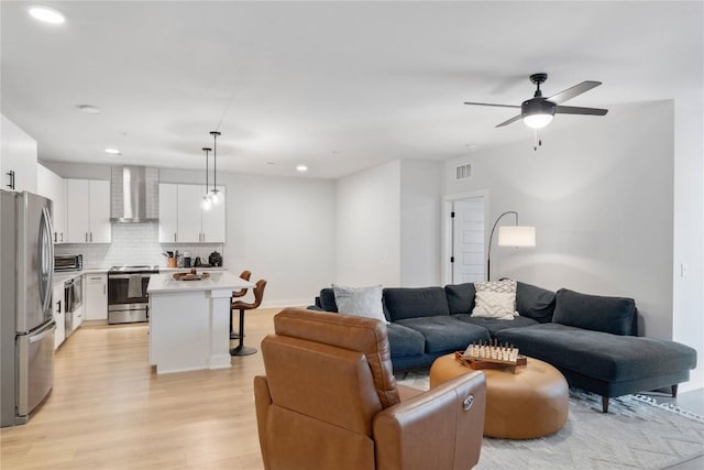 living area with recessed lighting, ceiling fan, visible vents, and light wood-style floors