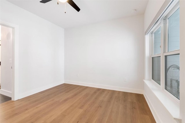 unfurnished room with light wood-type flooring, baseboards, and a ceiling fan