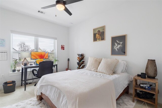 carpeted bedroom featuring a ceiling fan and visible vents