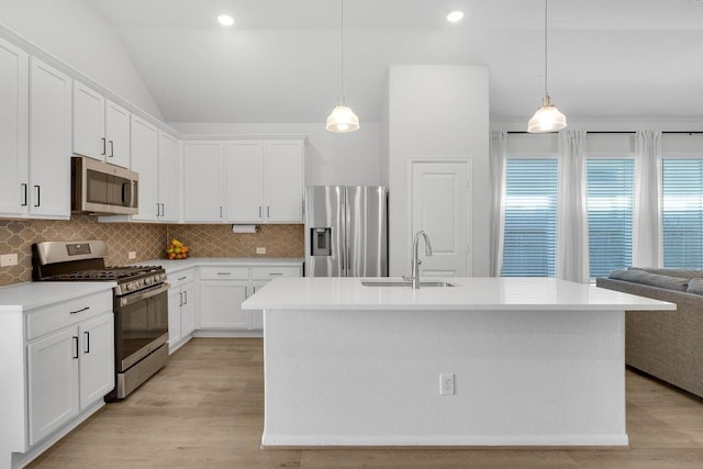 kitchen featuring decorative backsplash, appliances with stainless steel finishes, light wood-type flooring, and a sink