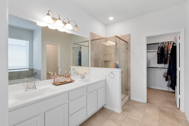 bathroom featuring double vanity, a stall shower, and a sink