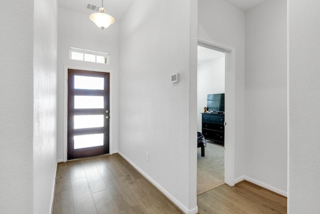 entryway featuring visible vents, baseboards, and wood finished floors