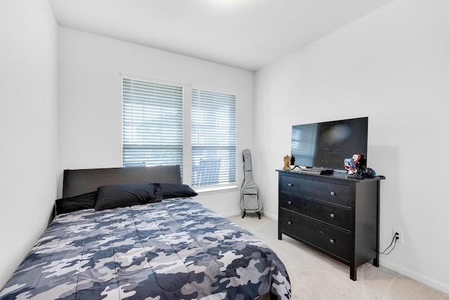 bedroom with baseboards and light carpet