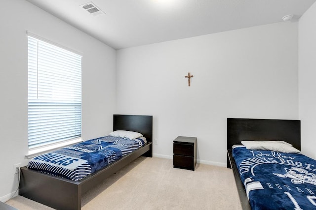 carpeted bedroom with visible vents and baseboards