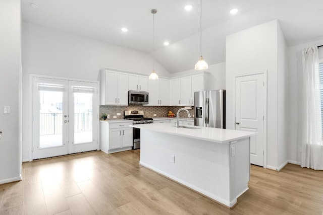 kitchen featuring a sink, decorative backsplash, light countertops, white cabinets, and appliances with stainless steel finishes