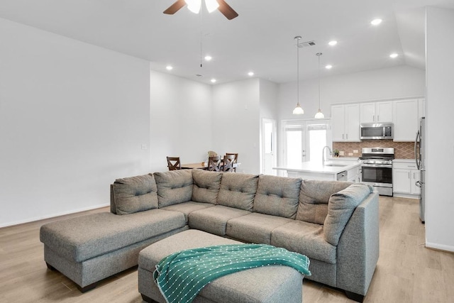 living area with recessed lighting, visible vents, a ceiling fan, and light wood finished floors