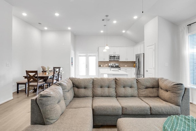 living area with visible vents, recessed lighting, baseboards, light wood-style floors, and lofted ceiling