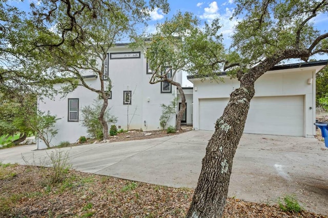 view of front of property featuring concrete driveway, a garage, and stucco siding