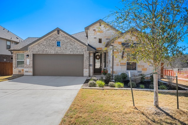 french provincial home featuring concrete driveway, fence, a garage, and a front lawn