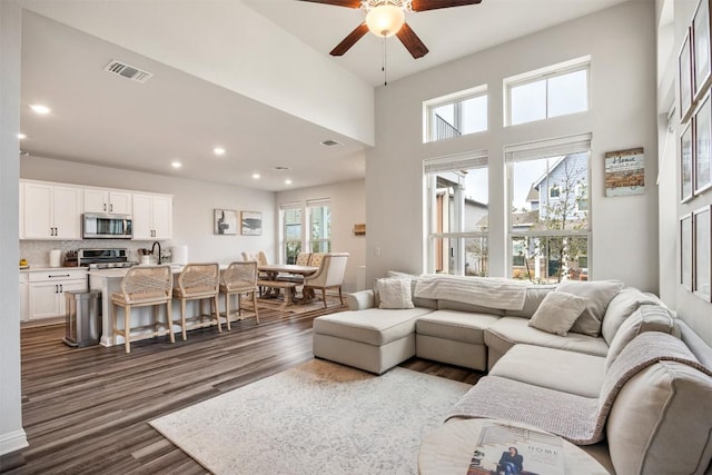 living room featuring recessed lighting, visible vents, dark wood-type flooring, and ceiling fan