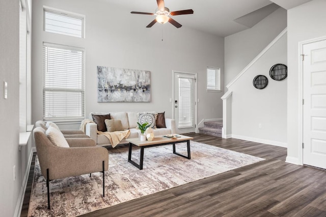 7902 Sutcliffe Dr, Austin, TX 78744 - living room featuring a ceiling fan, a high ceiling, wood finished floors, baseboards, and stairs