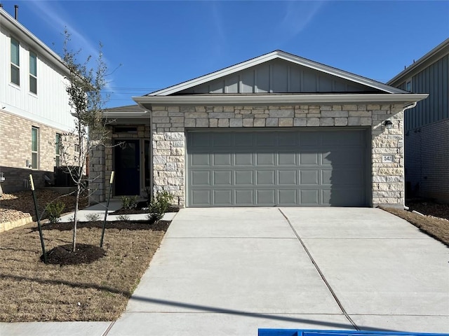 ranch-style home with stone siding, board and batten siding, an attached garage, and driveway