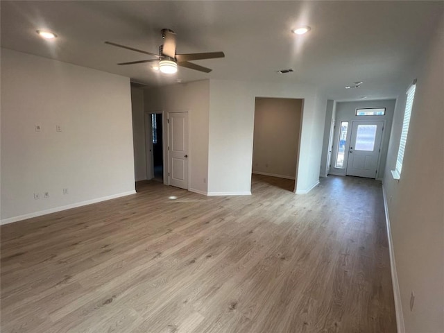 spare room with ceiling fan, light wood-style floors, visible vents, and baseboards