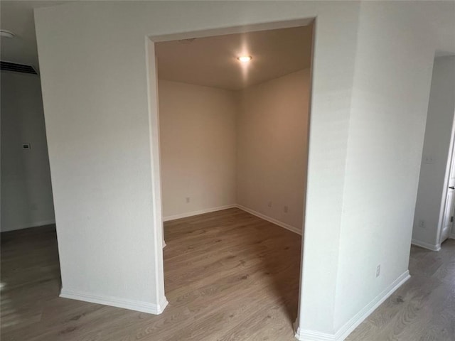 unfurnished room featuring visible vents, light wood-style flooring, and baseboards