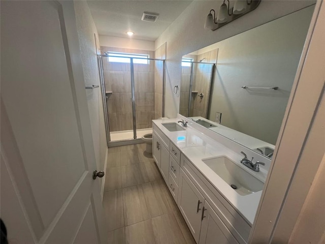 full bathroom with visible vents, a shower stall, toilet, and a sink