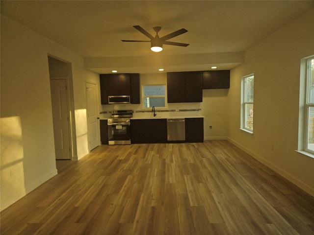 kitchen featuring light countertops, wood finished floors, baseboards, and stainless steel appliances