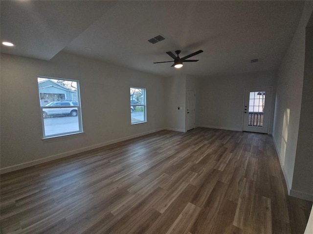 spare room featuring visible vents, baseboards, dark wood-style flooring, and ceiling fan