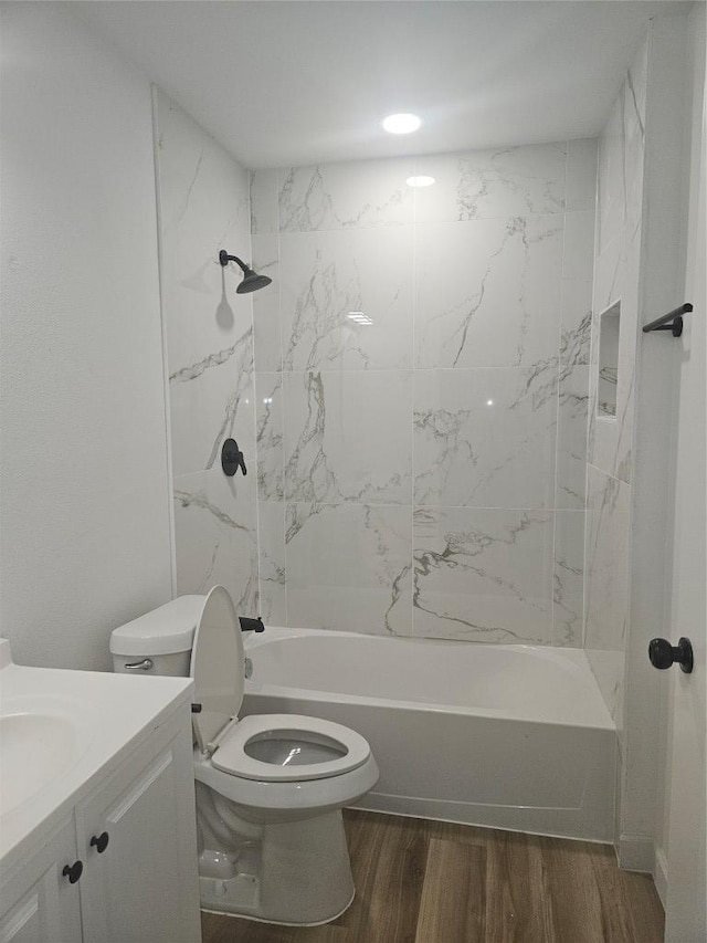 bathroom with toilet, vanity, bathtub / shower combination, and wood finished floors