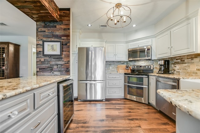 kitchen featuring visible vents, stainless steel appliances, decorative backsplash, wine cooler, and white cabinetry