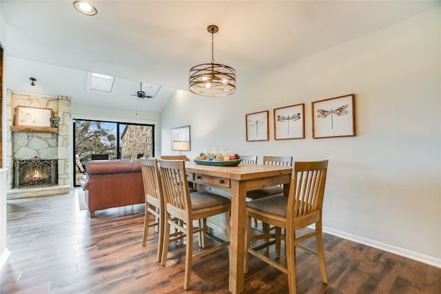 dining area with a fireplace, baseboards, lofted ceiling, and wood finished floors