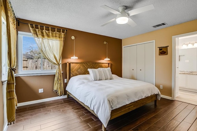 13202 Elysian Fields Cv, Austin, TX 78727 - bedroom with wood finished floors, a textured ceiling, a closet, connected bathroom, and a ceiling fan