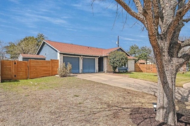 ranch-style house featuring a front yard, a gate, fence, concrete driveway, and a garage