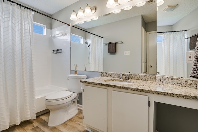 bathroom with toilet, shower / tub combo, wood finished floors, a textured ceiling, and vanity