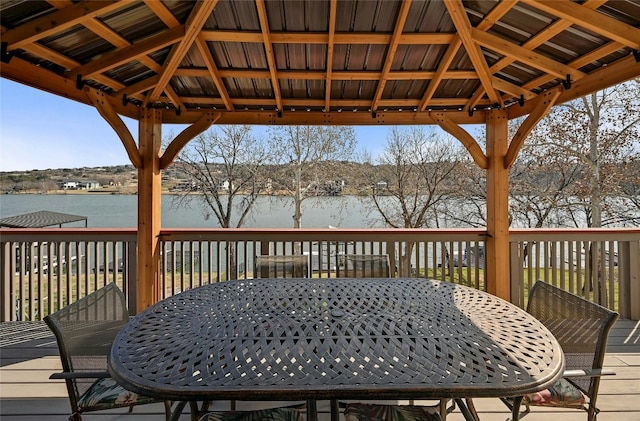 wooden terrace with a gazebo, outdoor dining area, and a water view