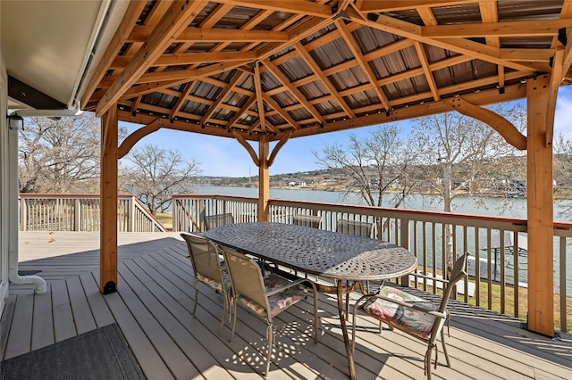 wooden deck featuring outdoor dining space, a gazebo, and a water view