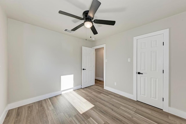 unfurnished bedroom with a ceiling fan, baseboards, visible vents, and light wood finished floors